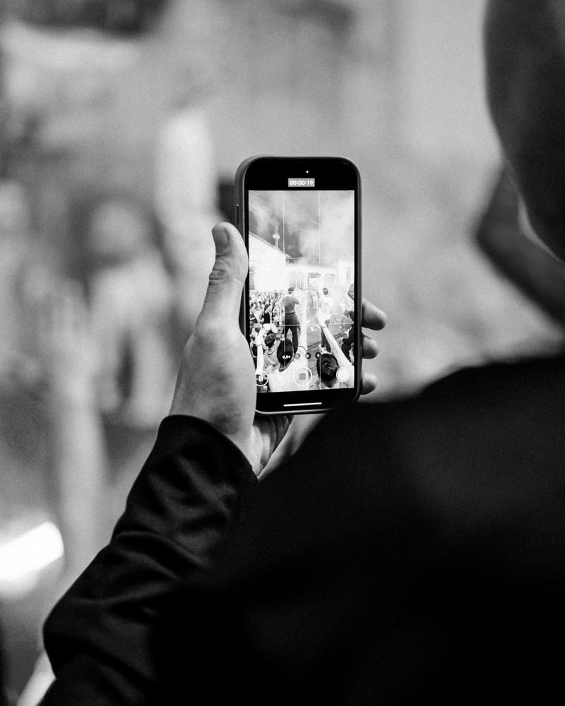 A fan filming the celebrations in the stands on their phone